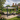 Patio with pergola, outdoor furniture, and flowers in a garden setting.